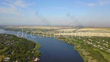 空中俯瞰蓝色河流，<strong>小村</strong>庄和河岸上的田野，无人驾驶飞机拍摄乡村夏季景观